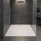 Duschwanne in weißer Steinoptik, bodeneben eingebaut in einer Dusche mit anthrazitfarbenen Fliesen und Glaswand